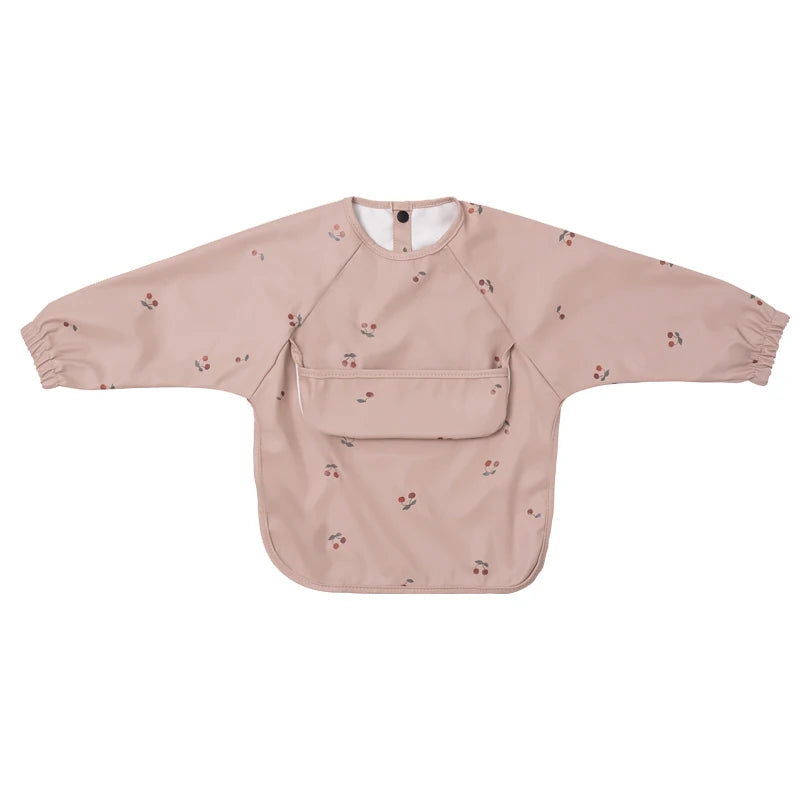 A light pink waterproof long-sleeve smock for toddlers with a chest pocket and a collar.