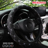 Black embroidered leather steering wheel cover installed in a car interior.