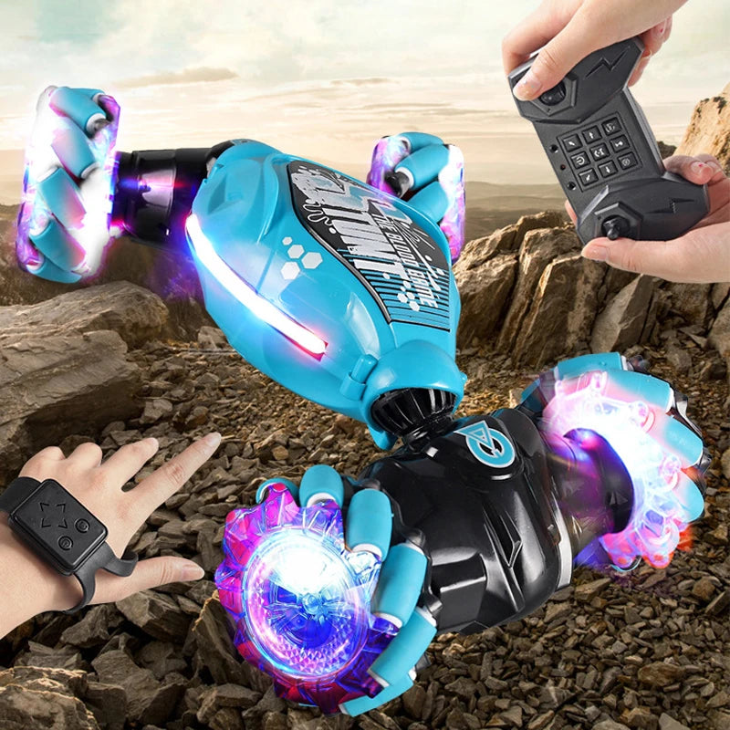 A hand holds a black RC stunt car with glowing blue and purple accents against a rocky background.
