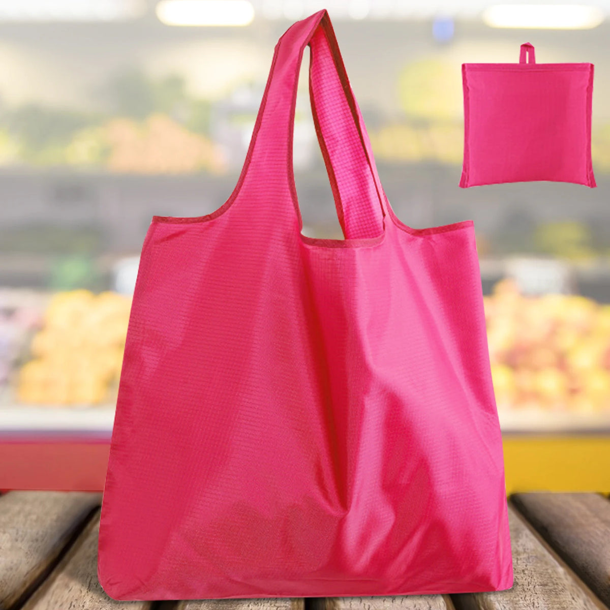 A bright pink reusable grocery bag is shown in a full view, with a smaller version visible in the background.