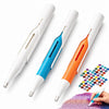Three automatic diamond painting bead dispenser pens in white, blue, and orange are shown next to a hand holding a paintbrush