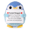 Handmade knitted blue and white penguin doll holding a card with a message