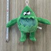 A green plush toy of an Opila Bird character is displayed next to a ruler.