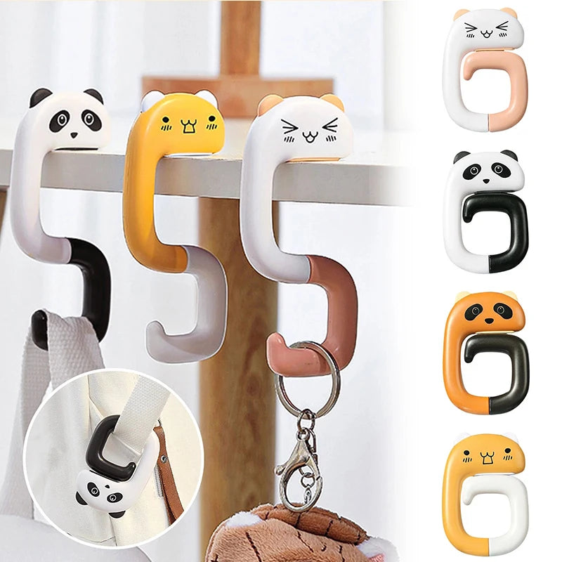 A set of portable bag hooks in various colors including black, white, yellow, and beige, shown hanging on a wooden surface.