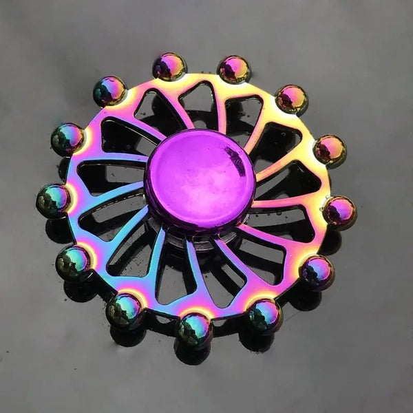 Un spinner anti-stress en alliage de zinc coloré avec un disque violet central et des accents métalliques.