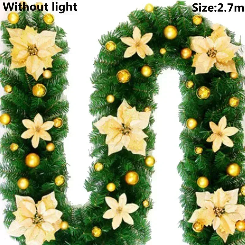 Green artificial Christmas garland with yellow flowers and gold ornaments, displayed without light.