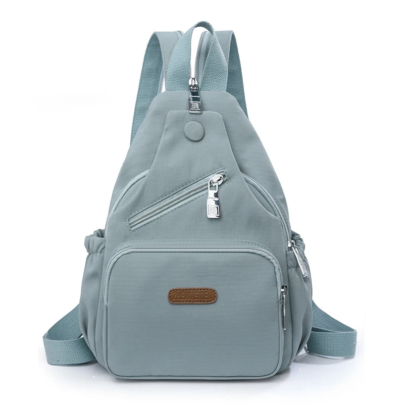 A light blue waterproof nylon crossbody sling bag worn on the back.