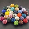 A collection of colorful crystal clay round beads in various shades and textures arranged on a dark surface.