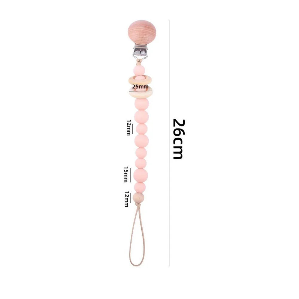 A wooden pacifier clip featuring a chain of pink crochet beads for baby teething.