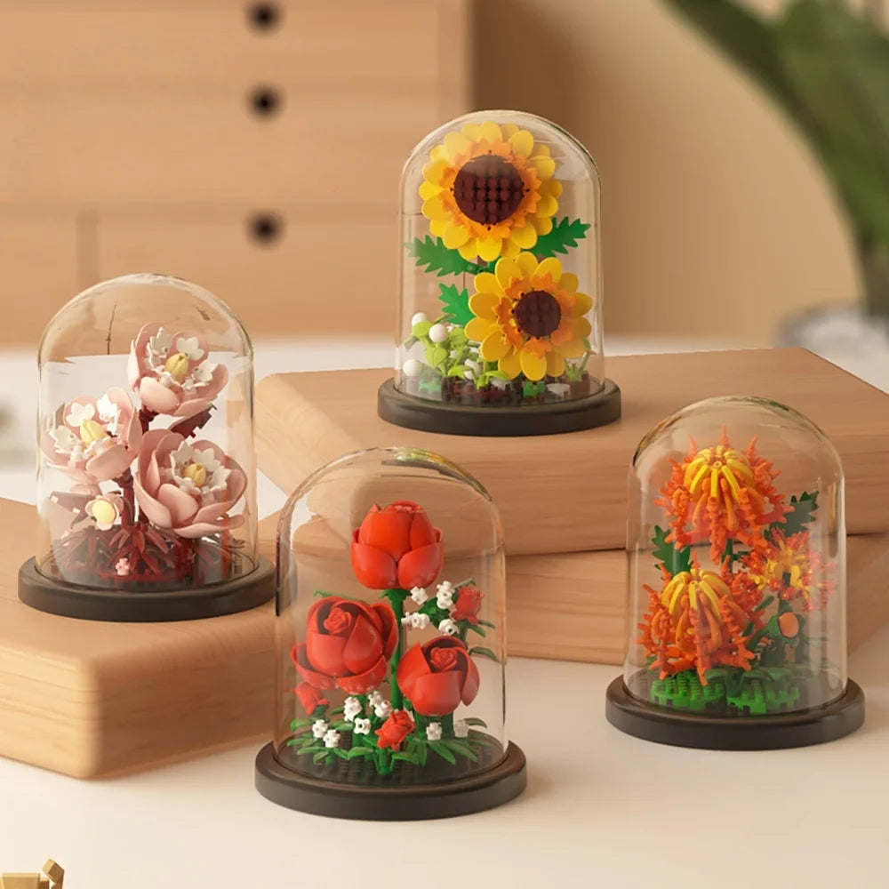 A set of glass cloches displaying miniature floral arrangements like roses and sunflowers built from micro building blocks.