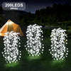 Three white willow light fixtures with 200 LEDs illuminate a grassy outdoor scene near a tent.