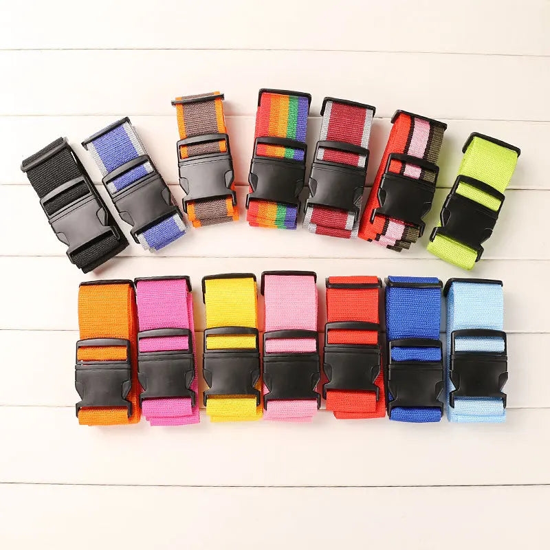 A collection of colorful adjustable polyester luggage straps arranged in a row.