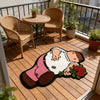 A playful cartoon carpet depicting a person in pink pants and a white shirt lying on a wooden deck.