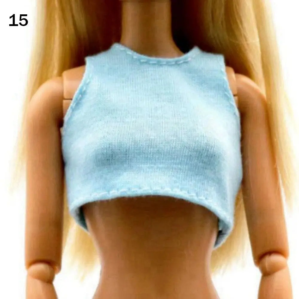 A fashion doll wearing a light blue, cropped, ribbed top.