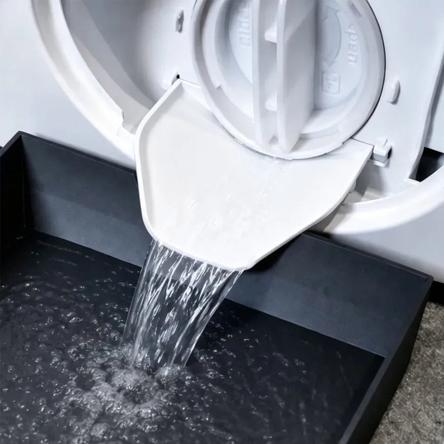 A white washing machine drain tray is shown with water flowing into the collection area.