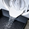 A white heavy-duty washing machine drain tray with a funnel is shown draining water into the basin.