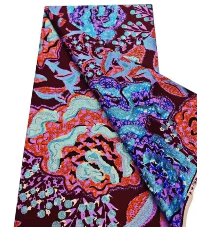 A close-up view of a vibrant pink glitter African wax print fabric with intricate floral patterns.