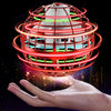 A hand holds a glowing, spherical magic flying ball with red and green LED lights orbiting around it.