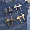 A set of four silver and gold Y2K star-shaped clips used as waist tighteners for jeans.