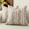 A close-up of a vintage striped floral throw pillow cover with muted olive green and beige tones.