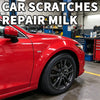 A red car body panel is shown with a scratch repair milk product in the background.