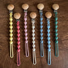 A collection of silicone pacifier clips with wooden teethers in various pastel colors arranged vertically.