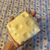 Eine Hand hält einen großen, blassgelben, weichen Stressball mit Maßen von 8,9 cm by 8 cm.