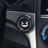 Close-up of a black rotating protective cover for a car ignition start button with Engine Start/Stop markings.