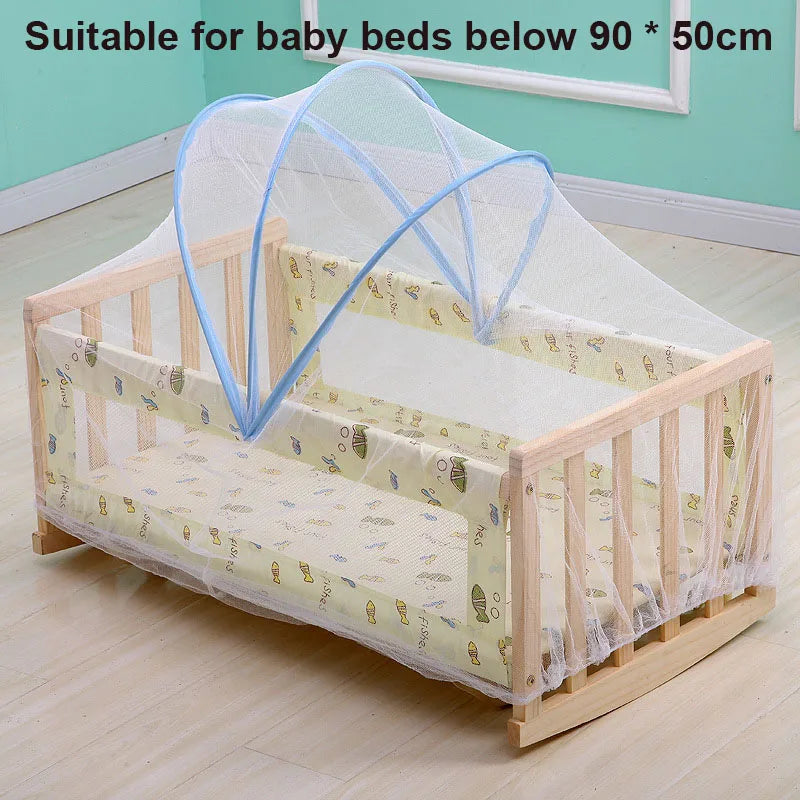 A wooden baby crib with a sheer mesh mosquito net installed for breathable protection.