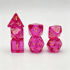 A set of seven translucent pink acrylic polyhedral dice, including a tetrahedron and several dodecahedral dice.