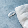 White plush fleece duvet cover with a rabbit design lying on a blue fabric surface.