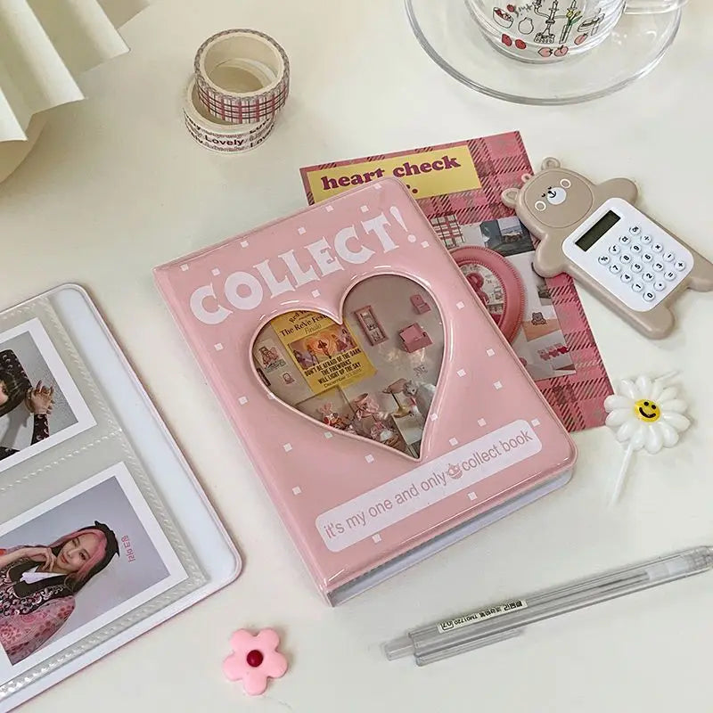 A pink mini photo album titled Collect with a heart design next to a heart check book and a small light gray device.