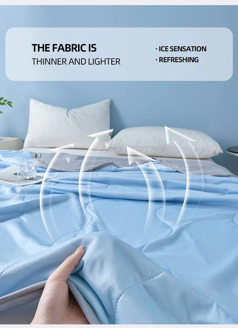 A hand is touching a light blue cooling quilt on a bed, illustrating the fabric's thinness and lightness.