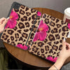 A leopard print floral tablet case for an iPad is shown resting on a wooden table.