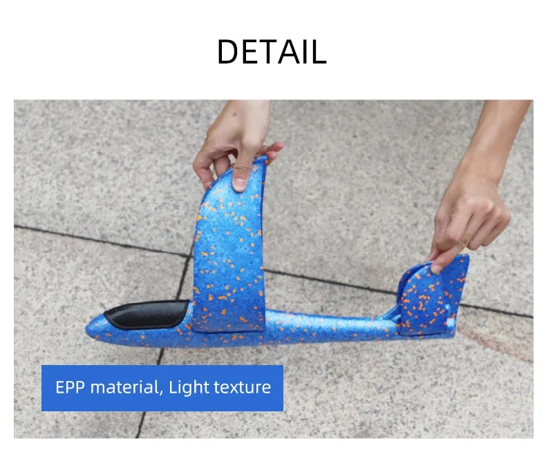A hand is holding a blue foam glider plane with a light texture, demonstrating the material detail.