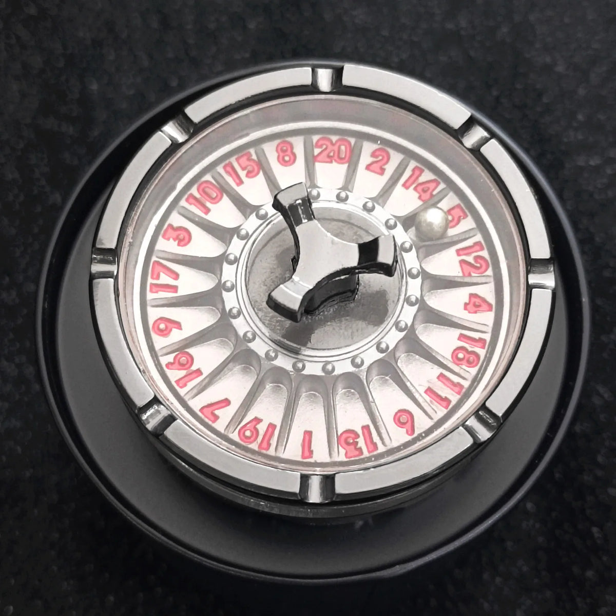 Close-up view of a metal roulette dice with numbered fingers for tabletop games