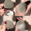 A set of 13 makeup brushes in a gray color being held and displayed against a light background.