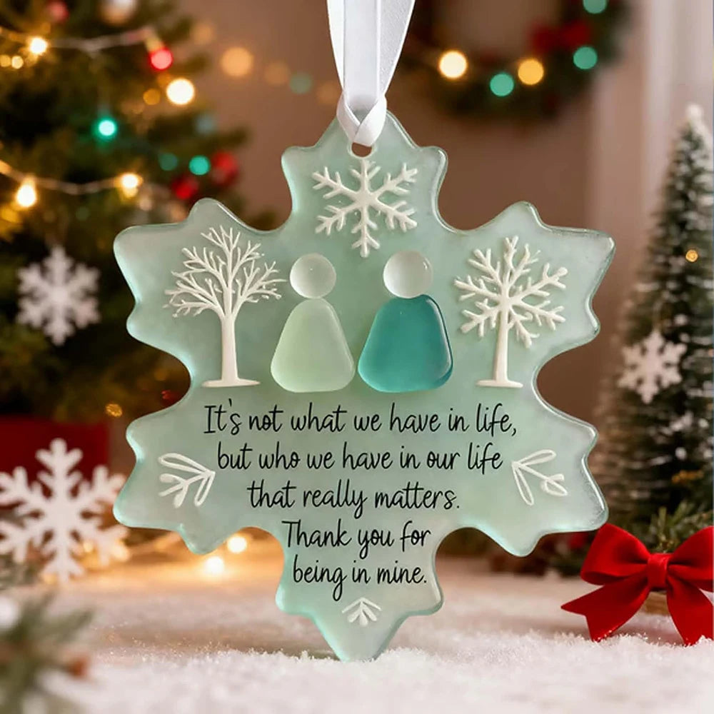 A handcrafted sea glass Christmas ornament shaped like a snowflake, featuring a quote about what truly matters.