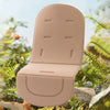 A beige cartoon baby stroller seat cushion is shown outdoors among green foliage.