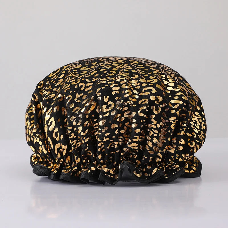 A black fabric shower cap with a leopard print pattern and gold accents.