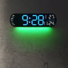 A digital wall clock displaying 9:28 with an RGB color changing feature mounted on a gray wall.