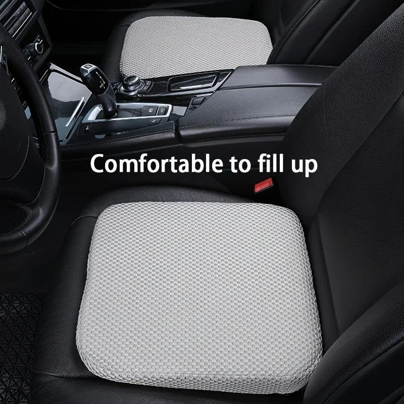 A gray ergonomic car seat cushion is shown placed in the interior of a car, demonstrating its fit and comfort.