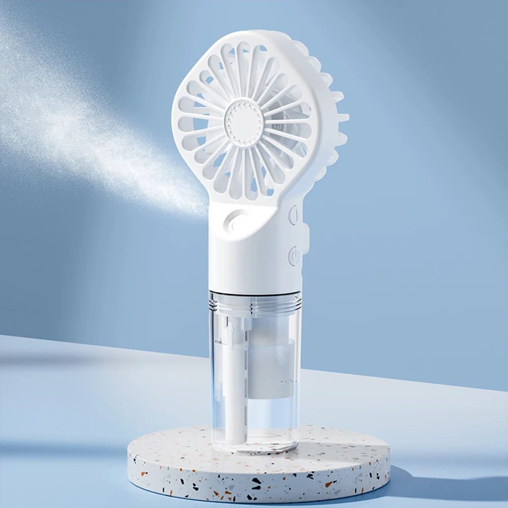 A white portable USB rechargeable mist fan with a perforated grille and a clear hydration bottle is displayed on a light surf