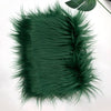 A swatch of dark green soft faux fur fabric used for DIY sewing, doll hair, and cosplay.