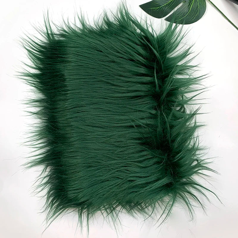 A swatch of dark green soft faux fur fabric used for DIY sewing, doll hair, and cosplay.
