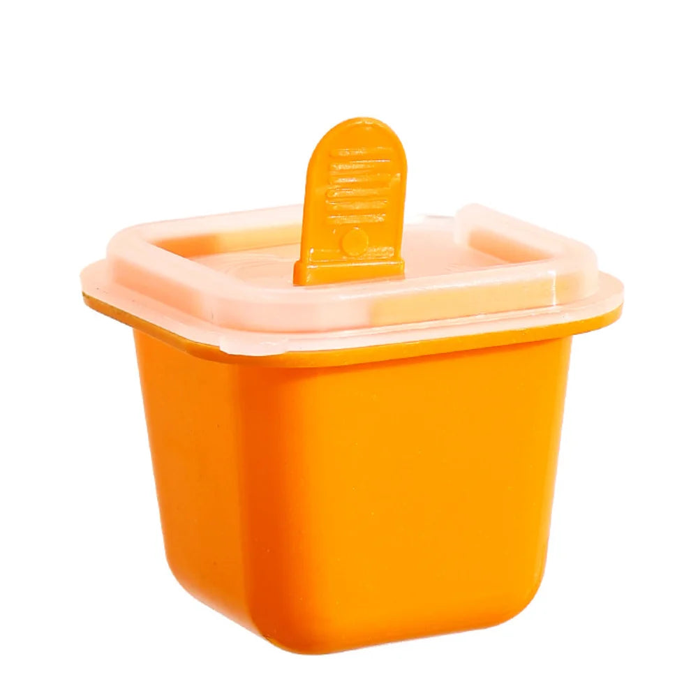 Moulin à glaçons en silicone orange avec un couvercle jaune.