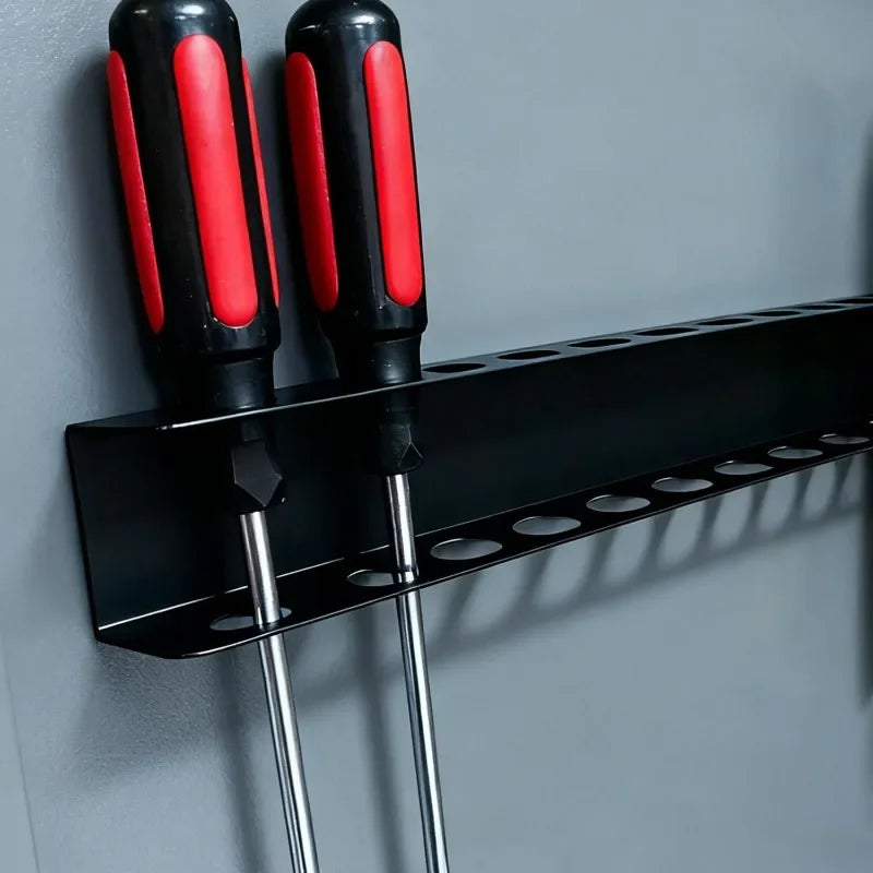 A black wall-mounted tool organizer with red and black handles for holding various tools.