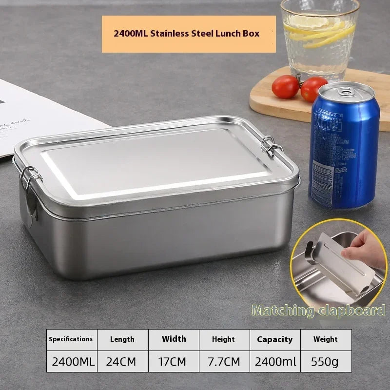 Une boîte à lunch en acier inoxydable argenté de 2400ML est montrée à côté d'une canette et de tomates sur une surface grise.