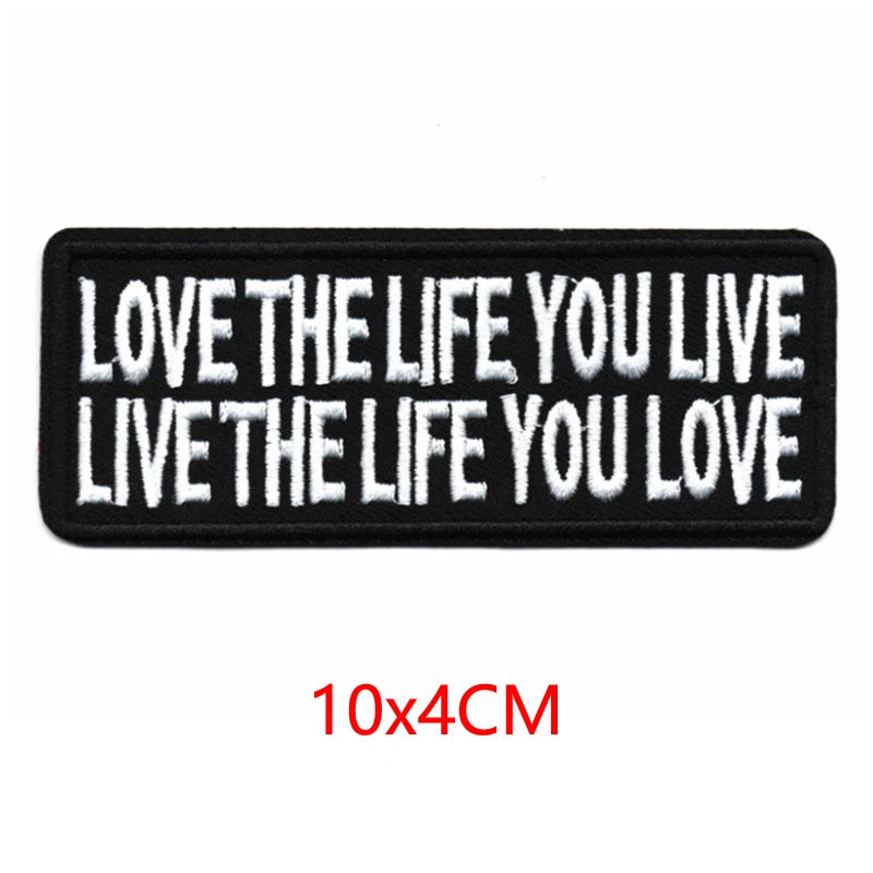 Black embroidered iron-on letter patch with white text that reads Love the life you live live the life you love