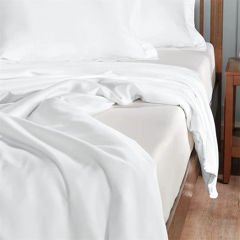 Weißes Luxus-Bambus-Bettwäsche-Set mit weichen Falten auf einem Bett.
